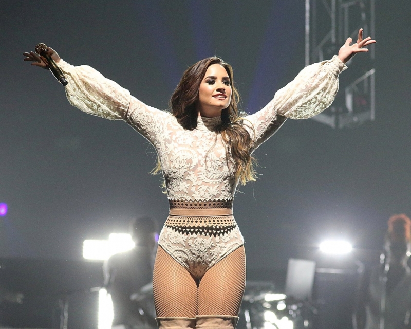 Demi Lovato beyaz kostümü ve fileli çorapla sahnede