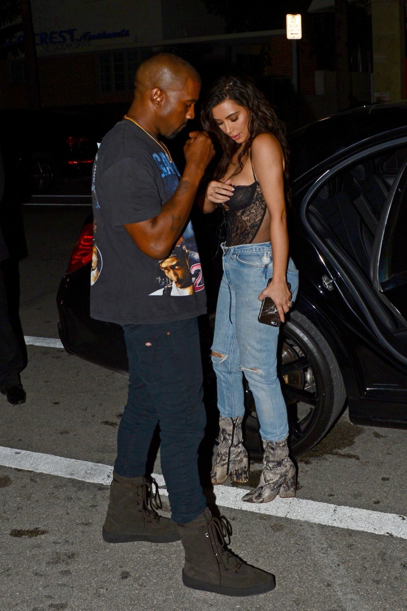 Kim Kardashian göğüs dekolteli siyah büstiyer ve kot pantolon ile