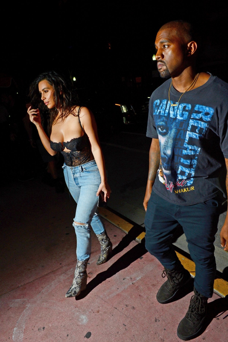 Kim Kardashian göğüs dekolteli siyah büstiyer ve kot pantolon ile